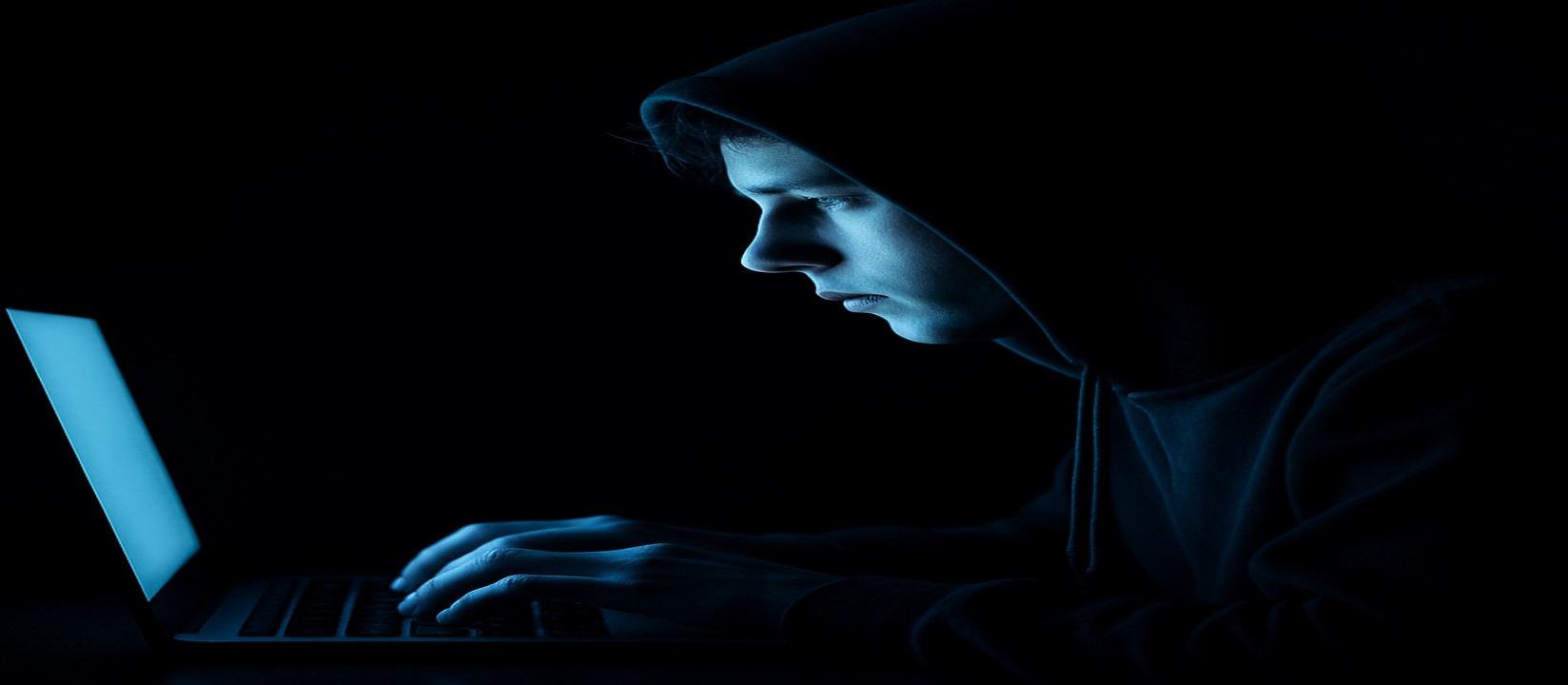 একজন ব্যক্তি অন্ধকারে ল্যাপটপে বসে একাগ্র দৃষ্টিতে মনোযোগী, bd1111 ওয়েবসাইটে অনলাইন গেমিং করছেন